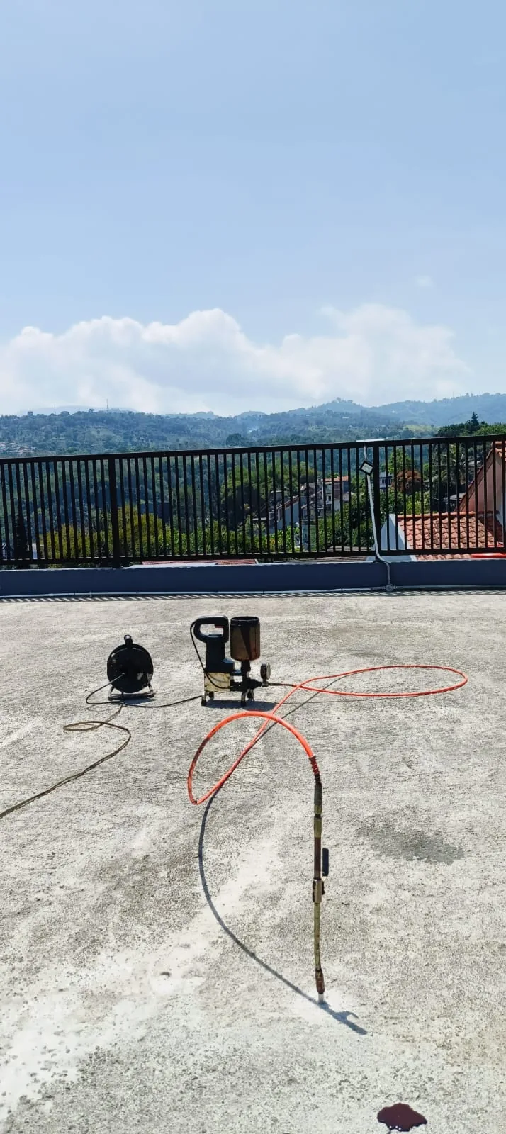 Peralatan pompa dan selang injeksi pada bidang dak beton di Bandung.