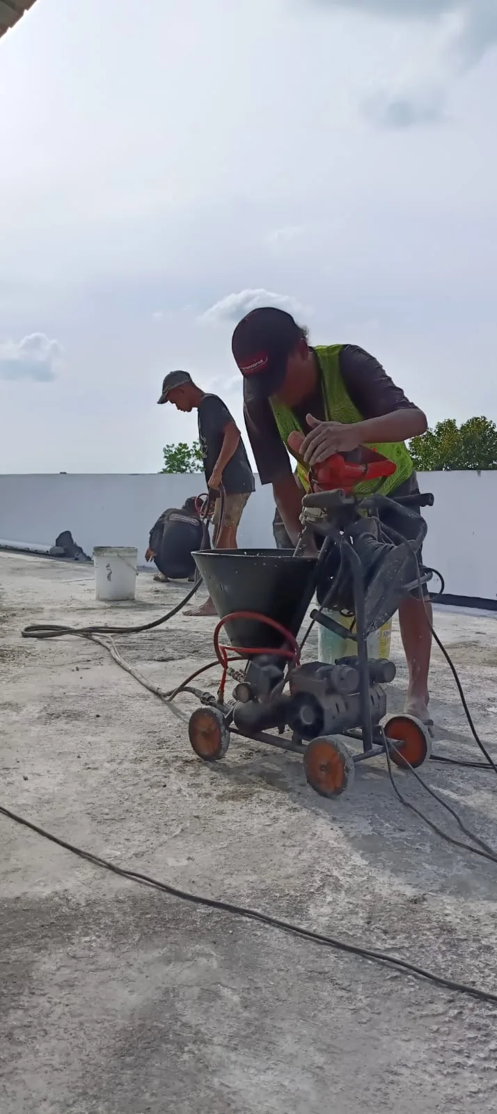 Tim menyiapkan peralatan pompa dan selang untuk pekerjaan waterproofing dak beton di Riau.